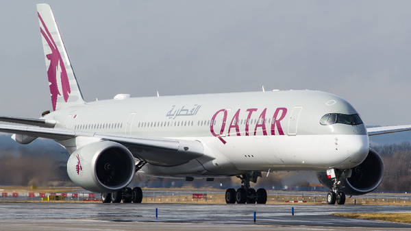 Blue cargo airplane in flight, representing air freight import-export services at Hamad International Airport.