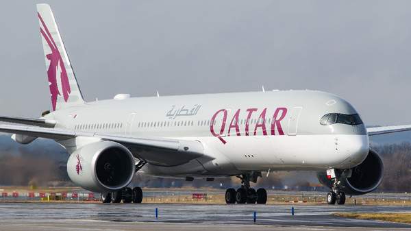 Blue cargo airplane in flight, representing air freight import-export services at Doha International Airport.