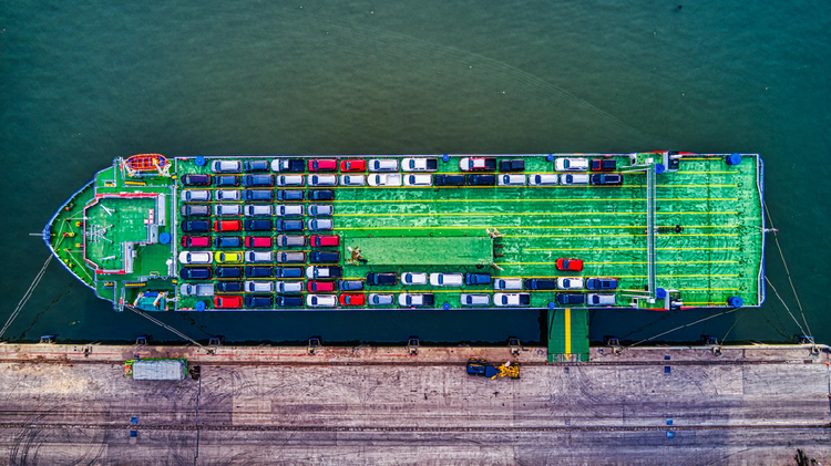 Aerial view of a cargo ship with vehicles onboard, ready for international transport.